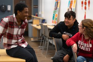 three students talking in the hub