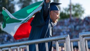 graduate walking to receive diploma with Mexican flag