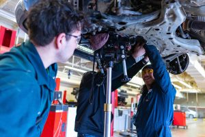 automotive students working under car