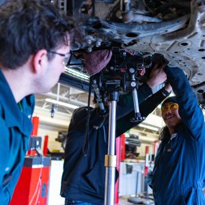 automotive students working under car