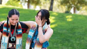 two Native American students laughing