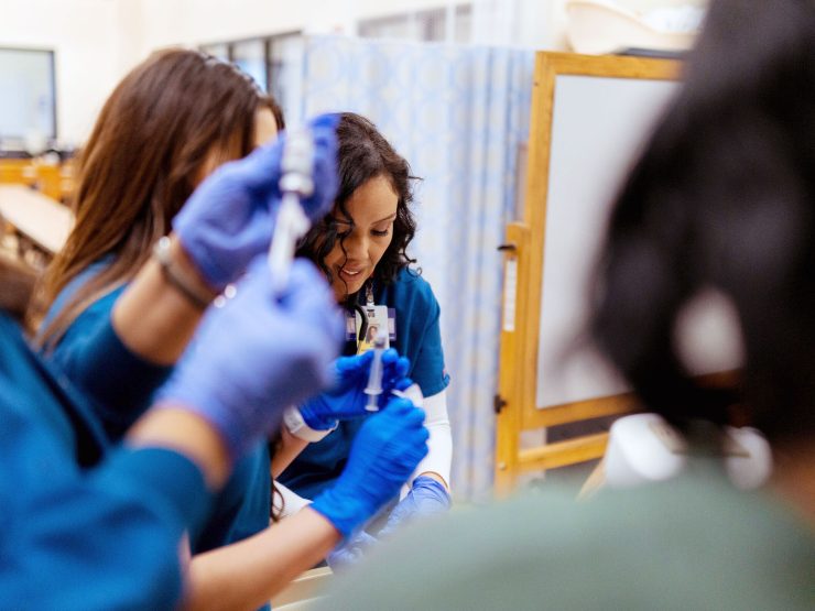 nursing students in class practicing techniques