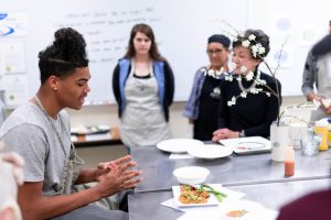 student presenting dish in nutrition class