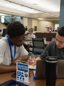 Two students engaged in one-on-one, in-person tutoring session.