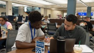 Two students engaged in one-on-one, in-person tutoring session.